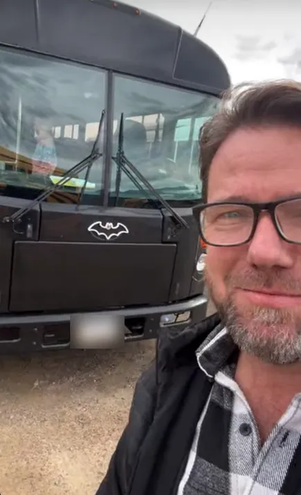 Jon taking a selfie in front of the black bus