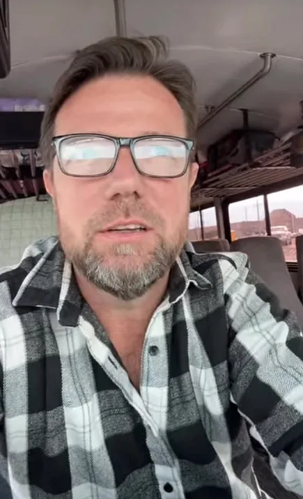 Jon smiling in a selfie on a bus