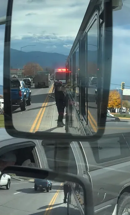 Mountain view through a bus window with the road ahead